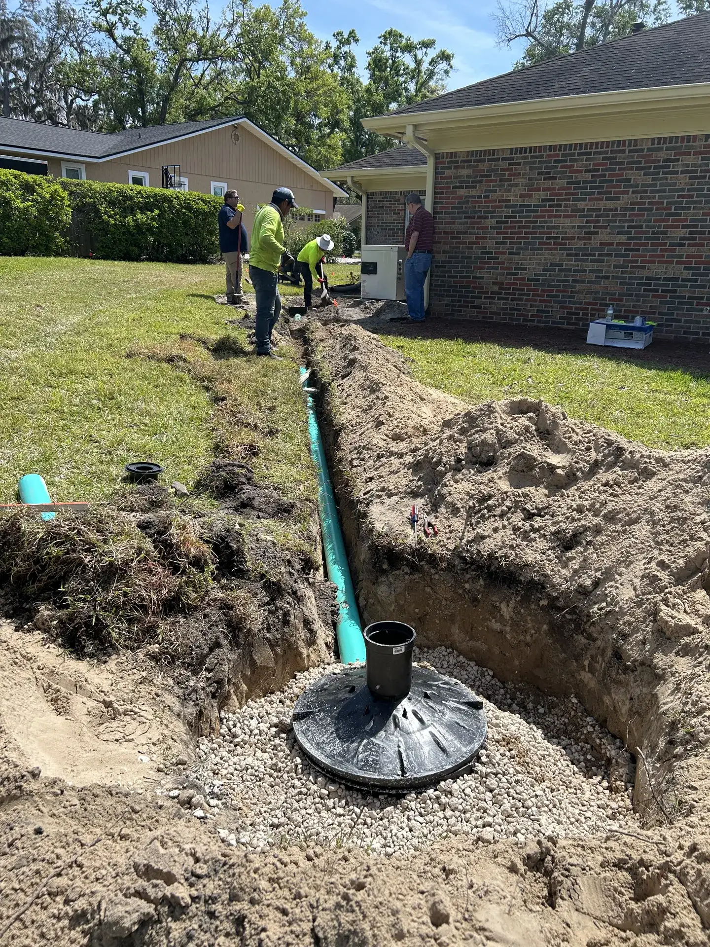 Crew installing a French drain and catch basin